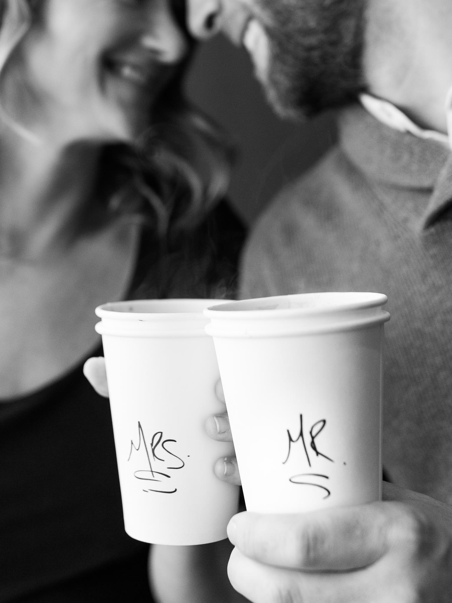 coffee shop engagement session posing ideas couple holding cups saying Mrs. and Mr.