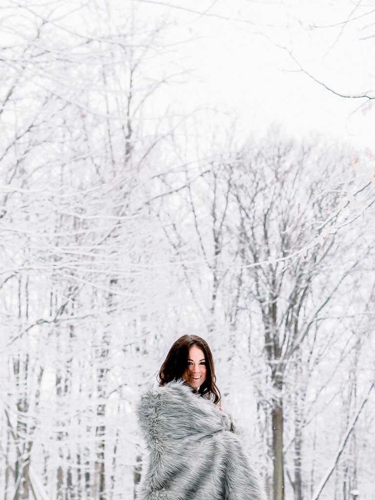 woman wrapped in gray blanket in snow