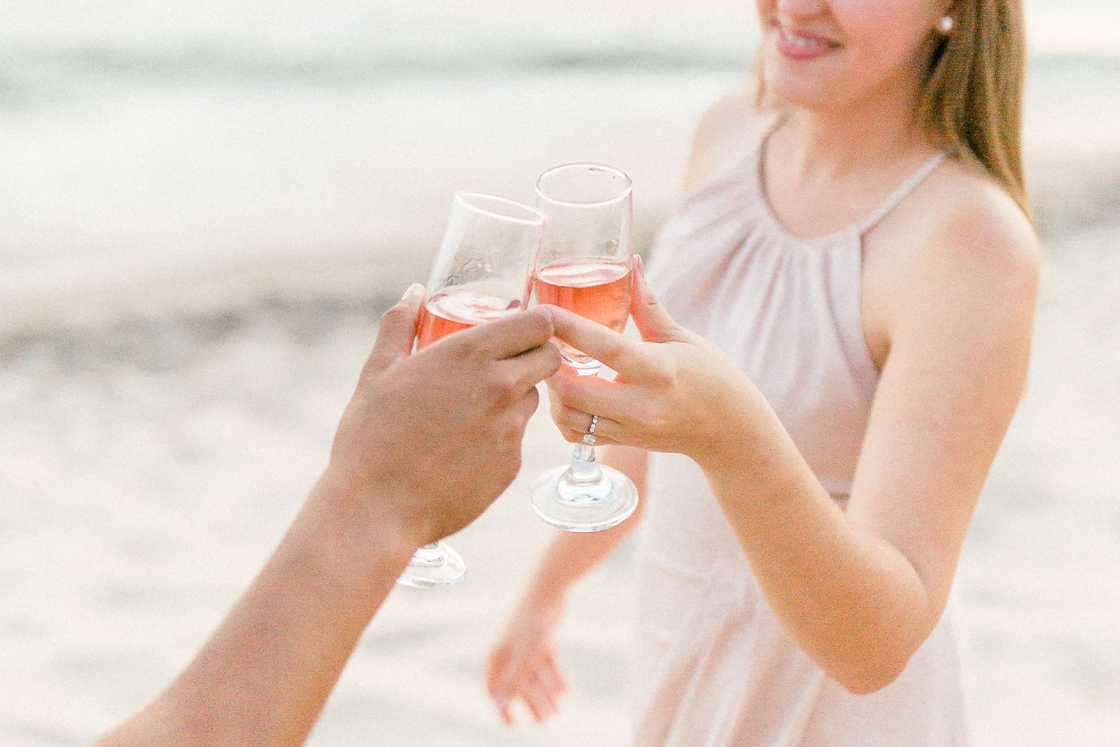 Beach engagement session champagne toast in blush dress