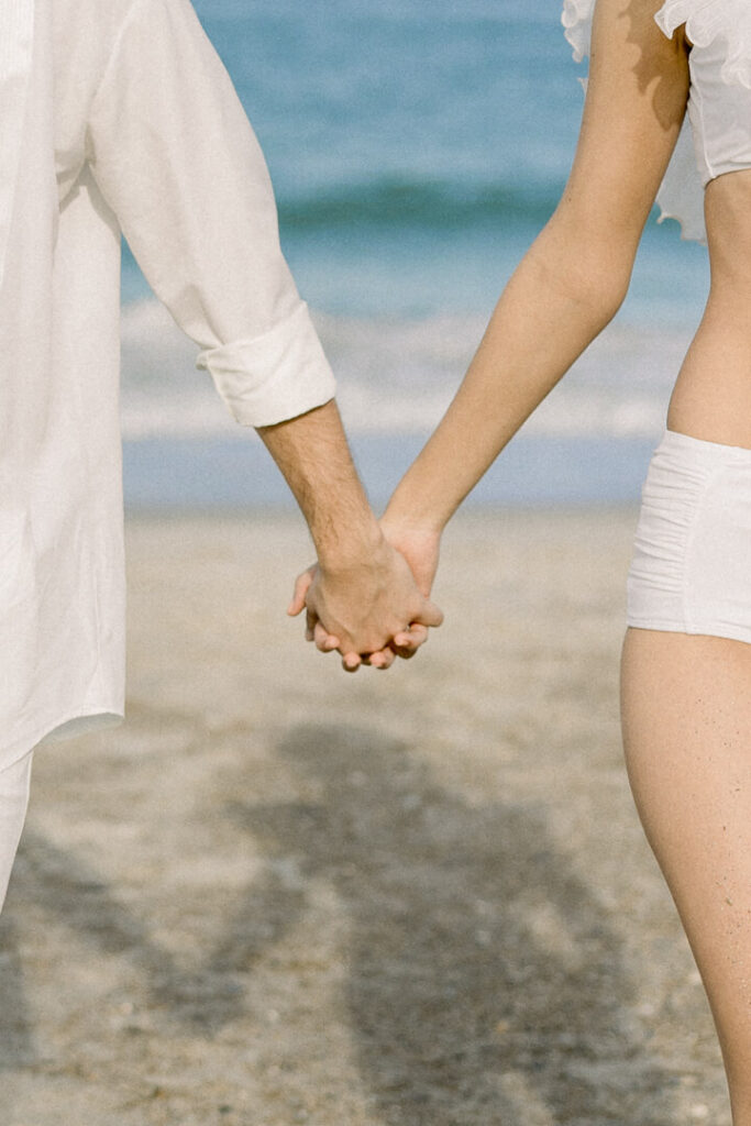 summer beach engagement session couple holding hand