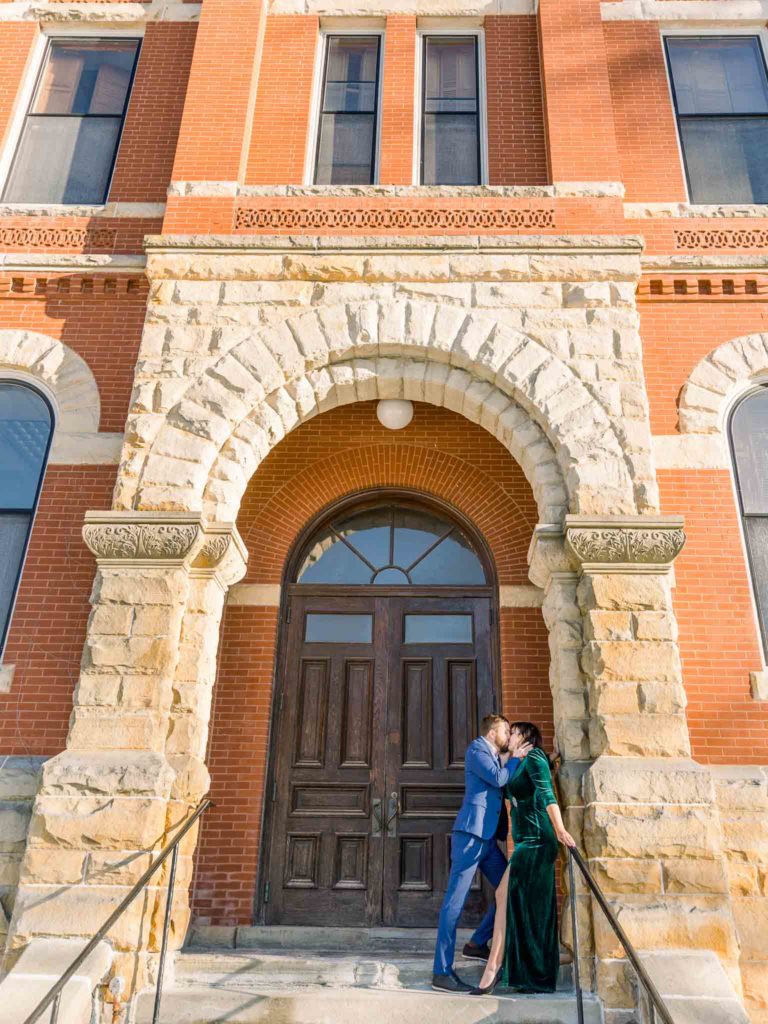 engagement session couple posing in front of Livingston County Courthouse entrance