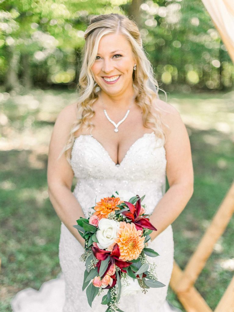 bride holding peach and blush bouquet