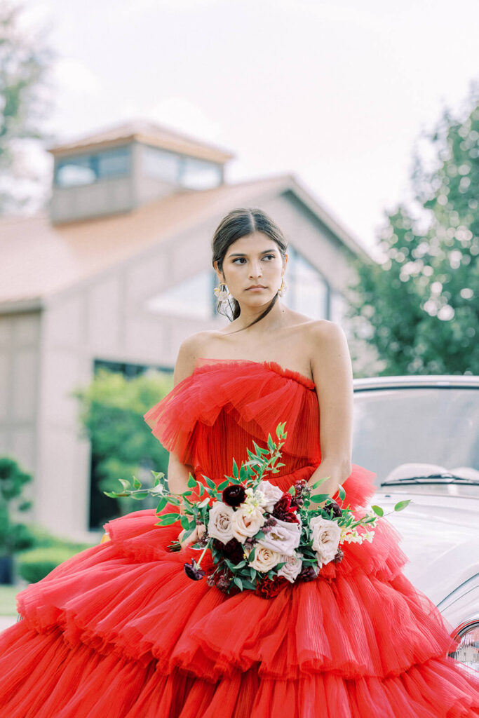 bride in puffy red tulle wedding dress with white vintage car