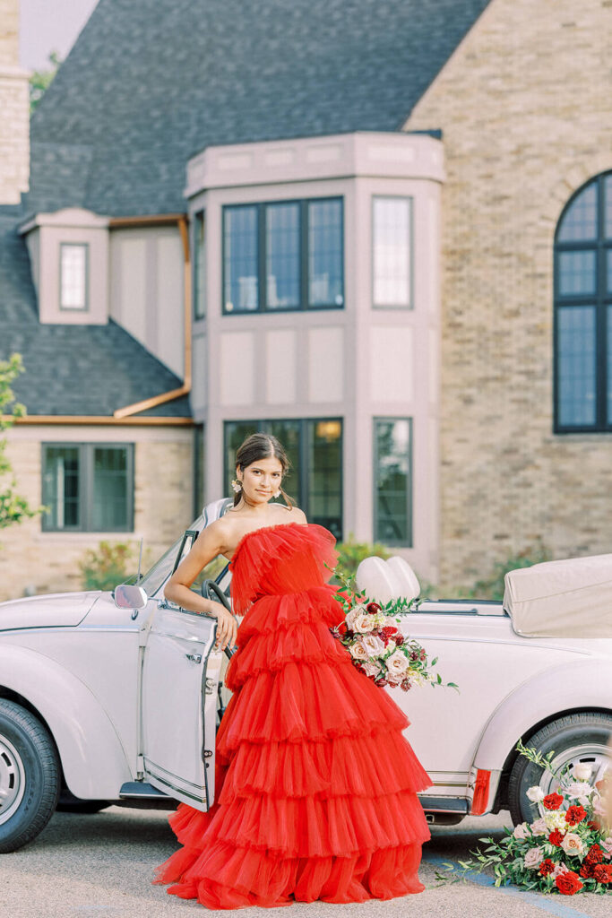 bride in puffy red tulle wedding dress with white vintage car at Venue3Two