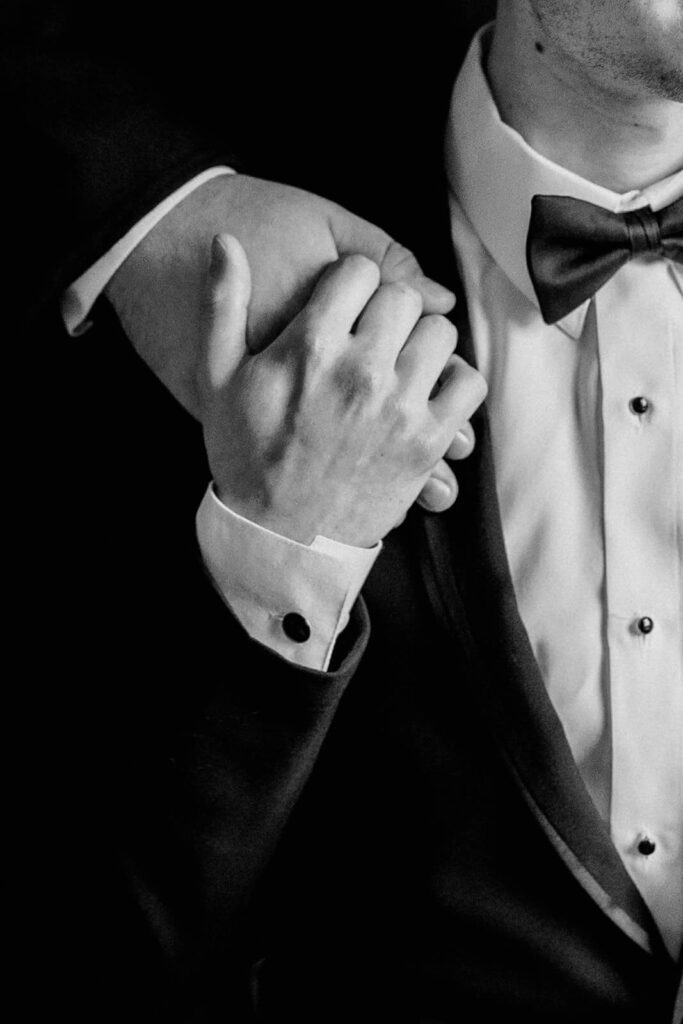 close up two grooms holding hands wedding portrait