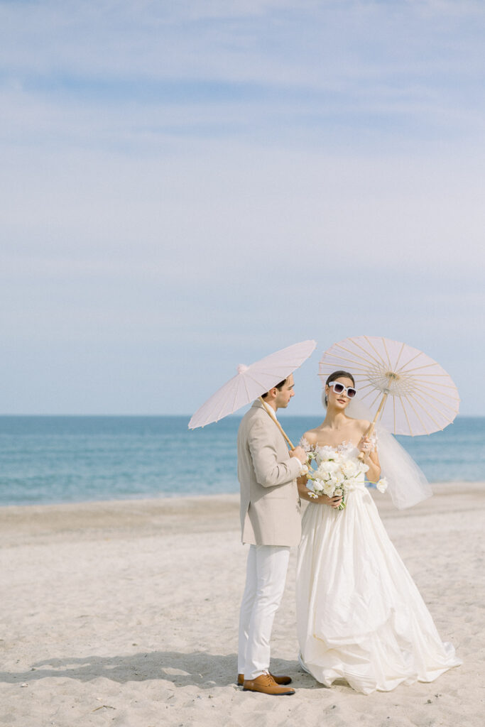 bride and groom portrait with paper parasol at Omni Amelia Island Resort beach wedding2